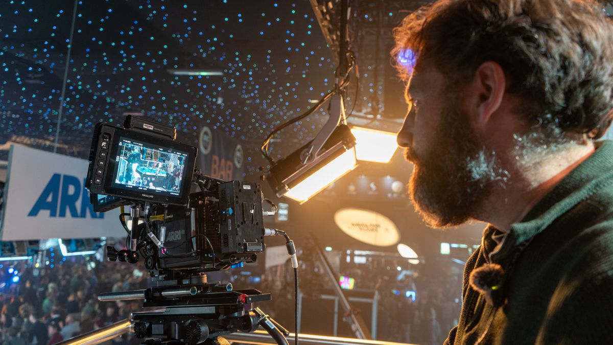 Adam Juniper operating a cinema camera at the BSC Expo under a ceiling of fake stars and cine lights