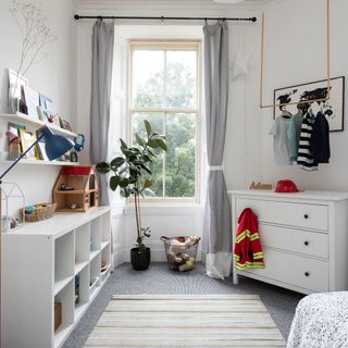 child's white room with drawers and carpet floor
