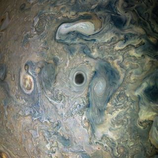 NASA's Juno spacecraft spotted a dark, eerie hole at the center of a cloud vortex in Jupiter's atmosphere. The dark spot, located in a Jovian jet stream, is surrounded by bright high-altitude clouds that appear brighter as they swirl in the sunlight. Juno captured this image on May 29 when the spacecraft was about 9,200 miles (14,800 kilometers) above Jupiter's cloud tops.