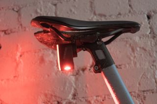 The underside of a rear bike light showing a large red LED bulb