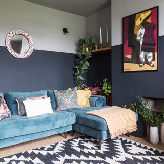 Living room maximalist style half painted navy and whitewall with blue velvet sofa