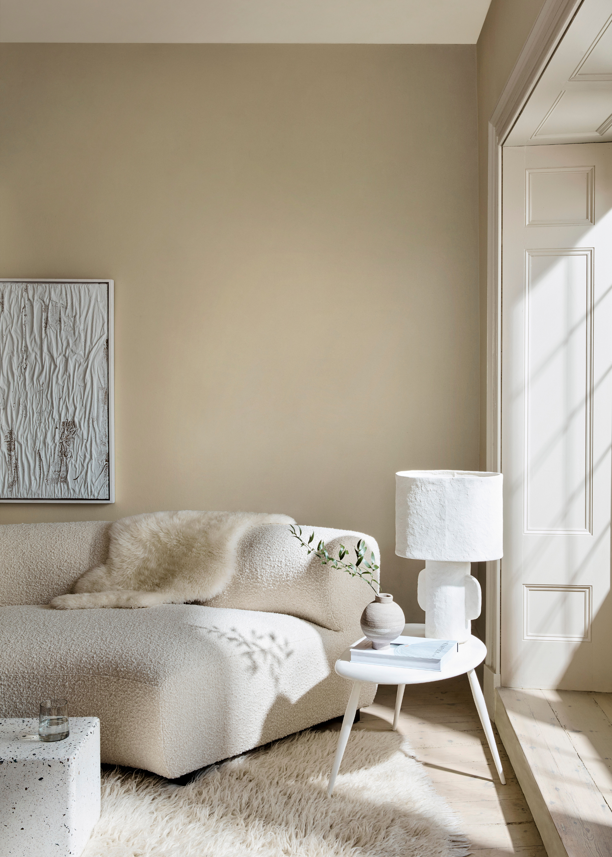 Neutral living room with wool rug and white lamp
