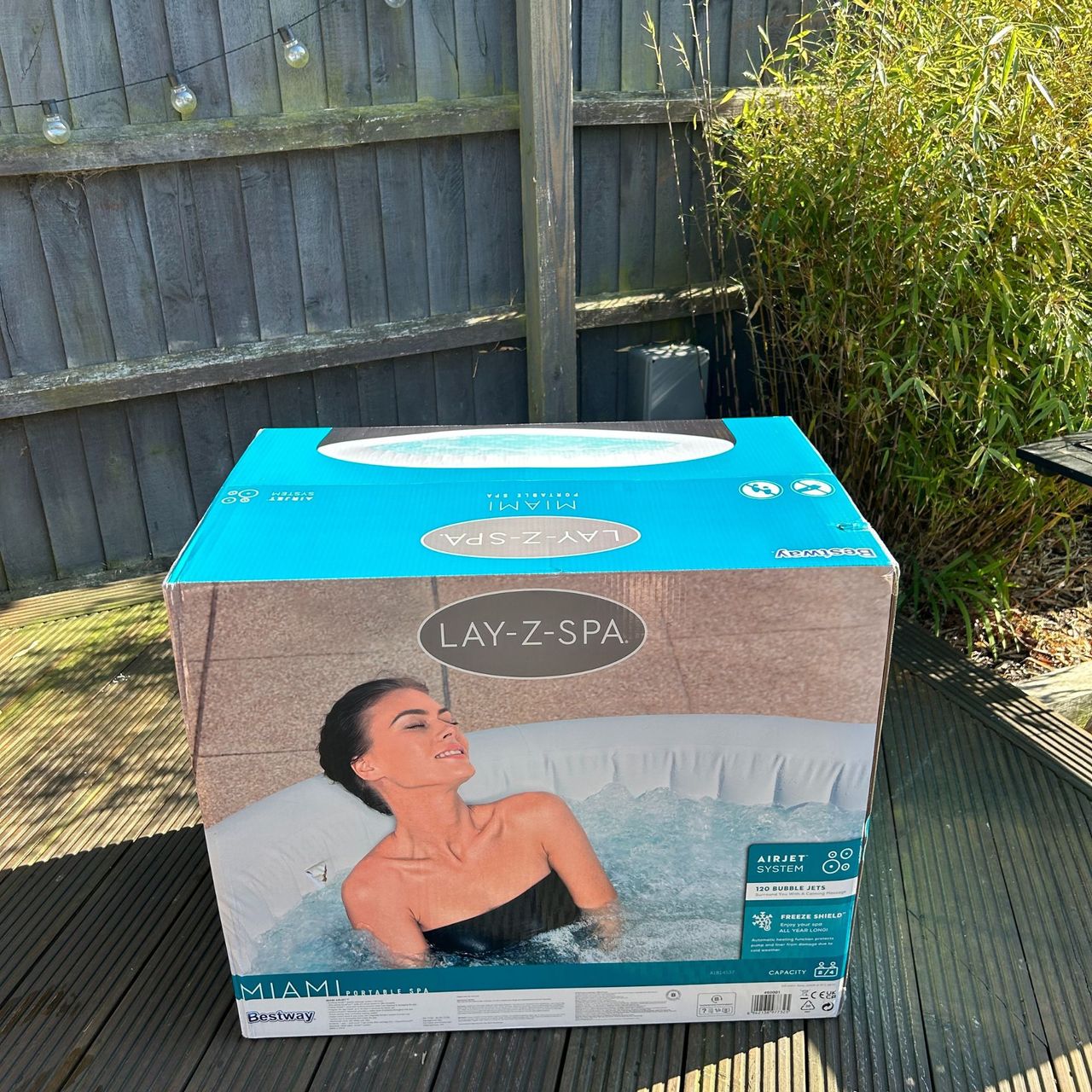 Lay-Z-Spa Miami AirJet in cardboard box on wooden decking