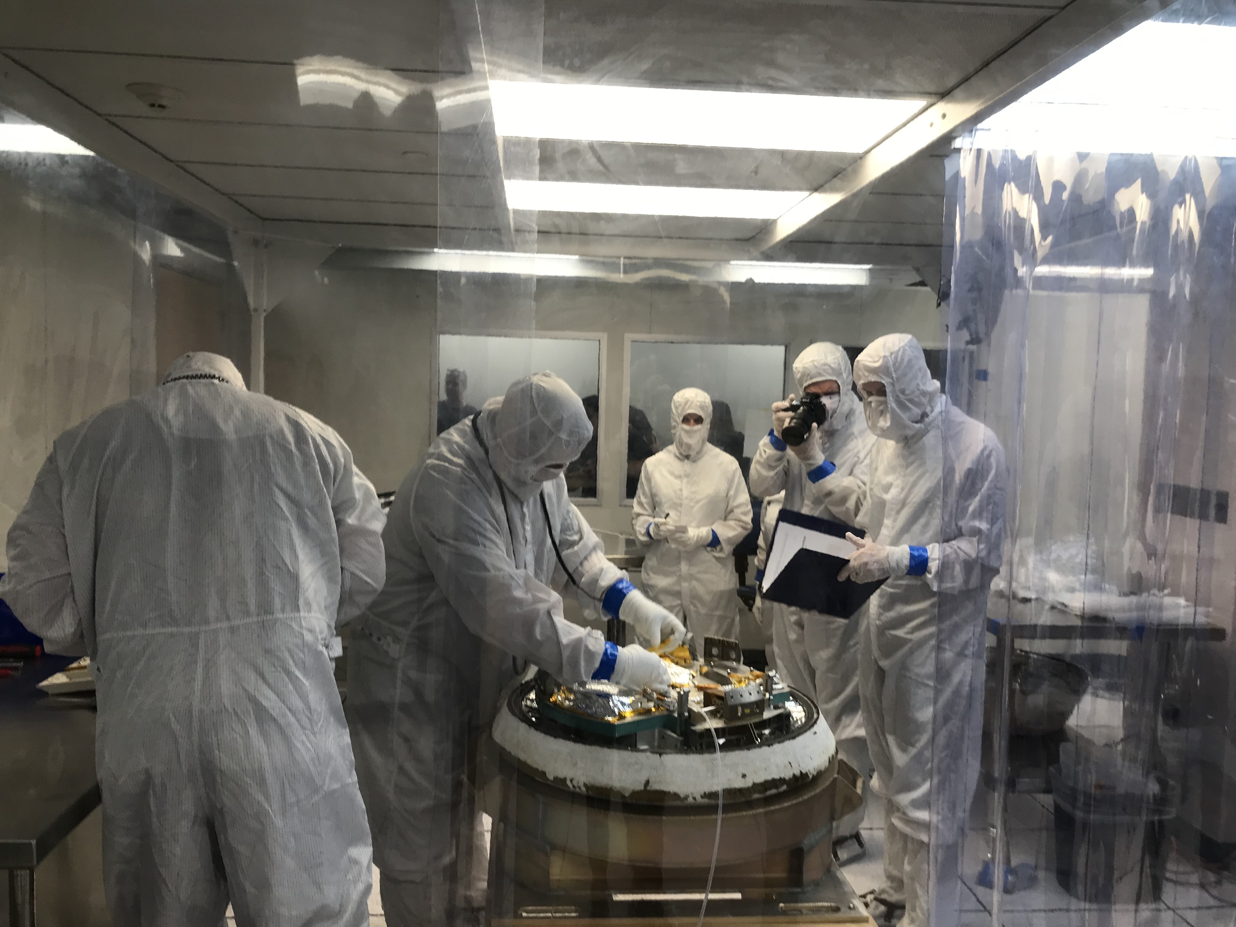 Practique una sesión de sala limpia en las instalaciones de Lockheed Martin cerca de Denver con especialistas que desmontan parcialmente la cápsula de retorno OSIRIS-REx.