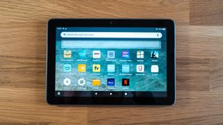 Amazon Fire HD 8 Plus home menu on a wooden surface