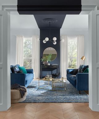 A white living room with navy wall paint decor on ceiling