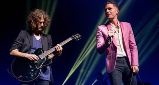 Dave Kuening plays an Ebony Gibson ES-335 live onstage with the Killers, and is flanked by frontman Brandon Flowers in a pink blazer