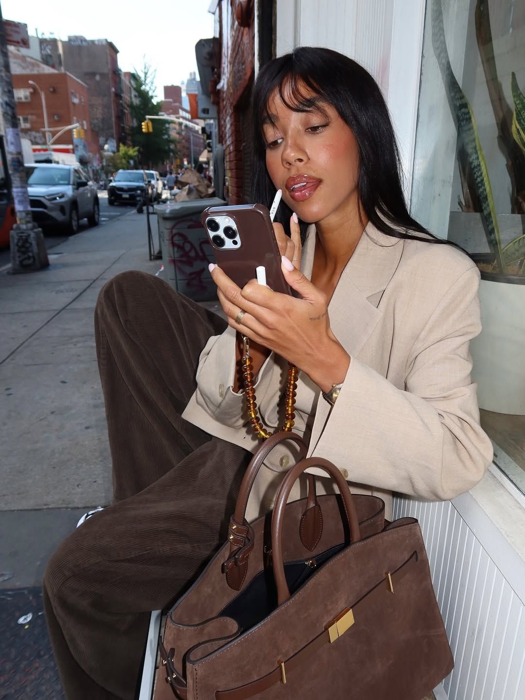Amaka Hameiljnck applies a shiny lip balm