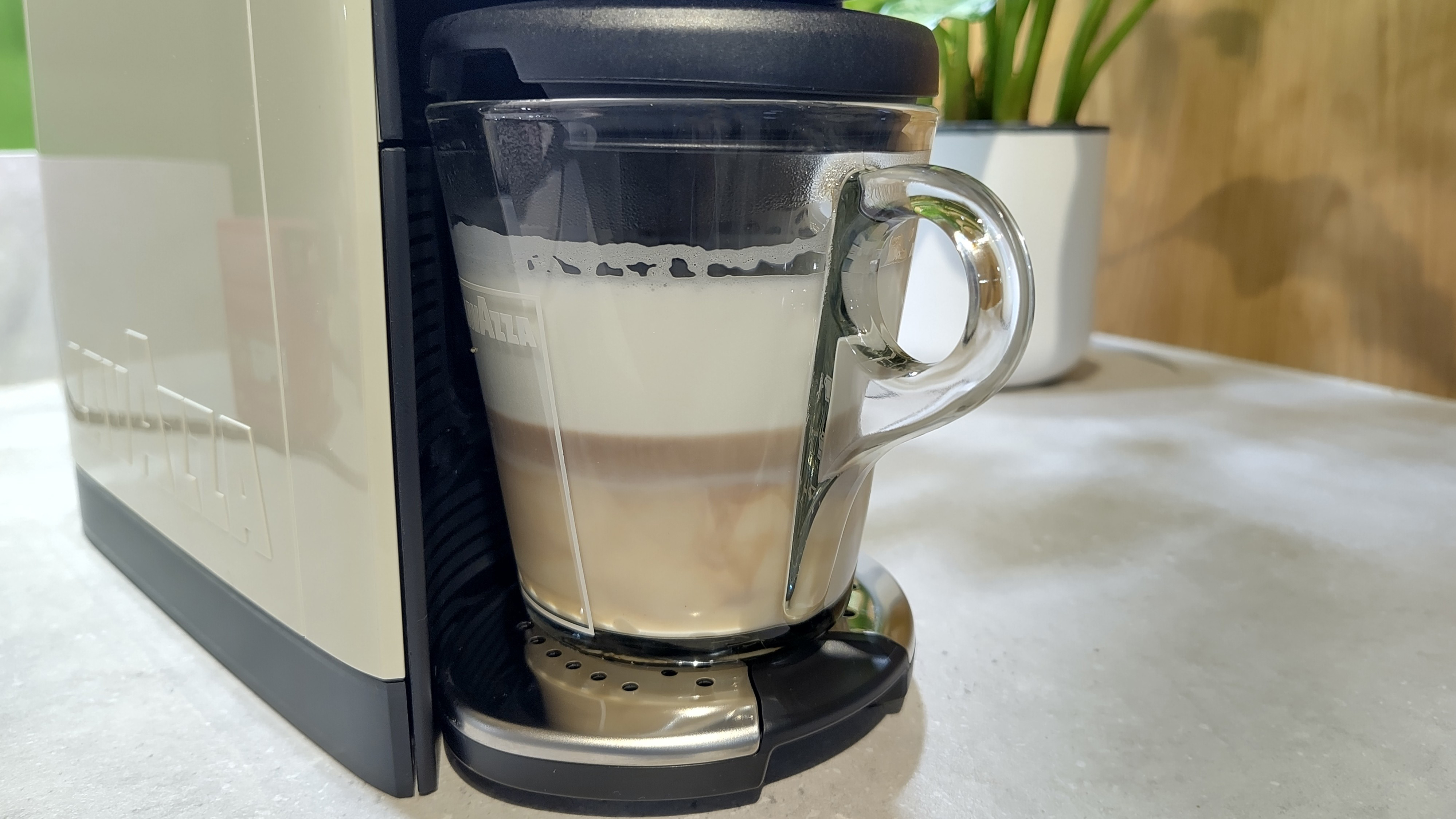 Lavazza A Modo Mio Des&amp;eacute;a coffee maker dispensing espresso into milk to make cappuccino