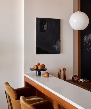 A white and wood peninsula kitchen island decorated with pretty kitchenware