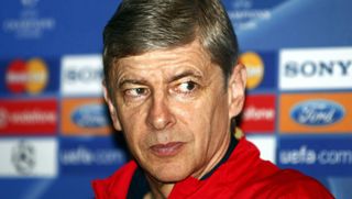 Arsene Wenger in front of a Champions League sponsorship board