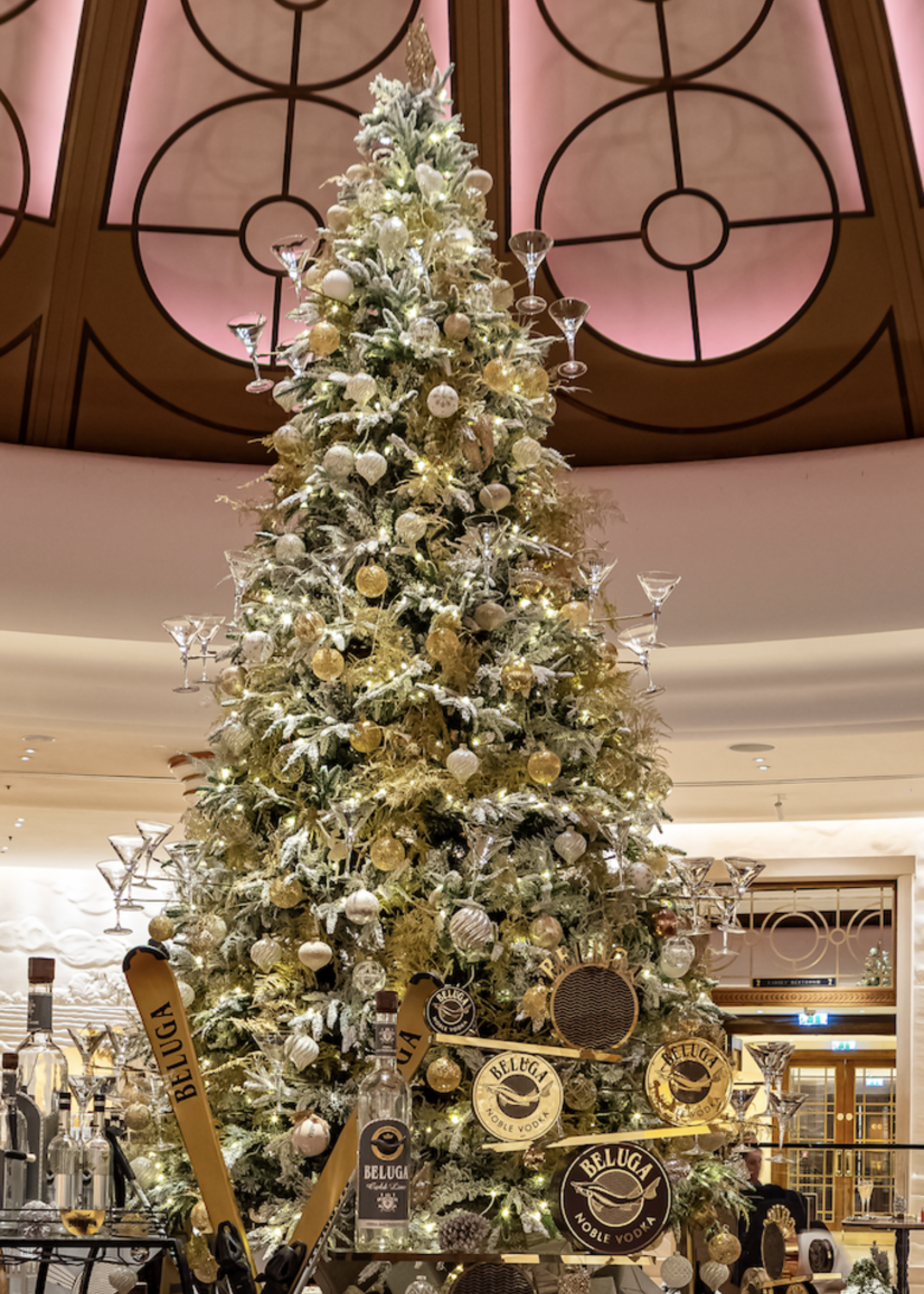 A close up of a Christmas tree with martini glasses on the branches