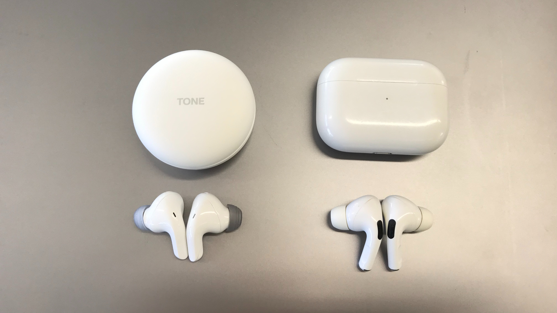 Lg Tone Free T90 and Apple AirPods Pro side by side on silver background