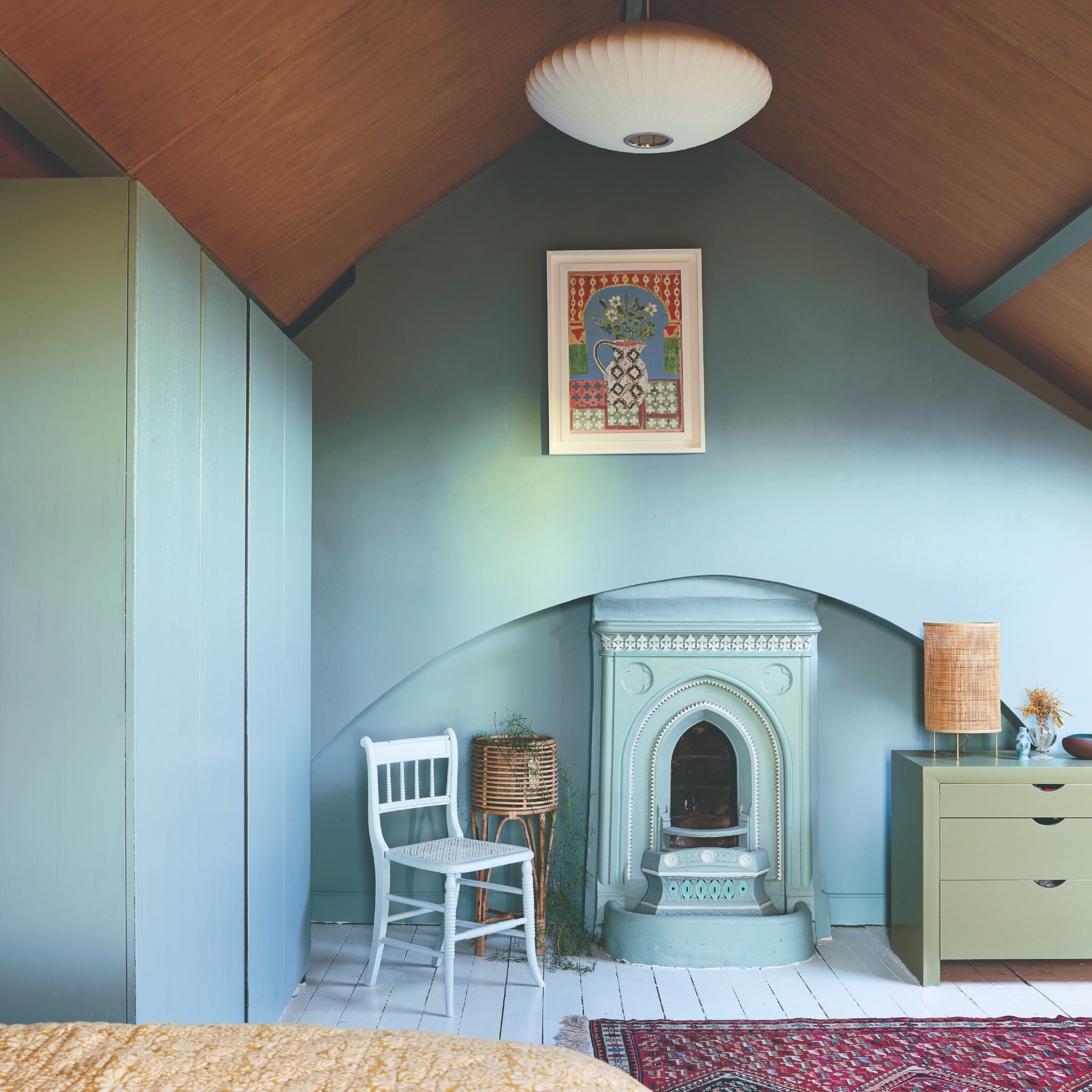 A soft blue colour drenched bedroom with painted floorboards and an arched wooden ceiling