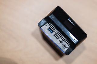 A blue and black Xulu XR1 Max mini PC on a wooden desk