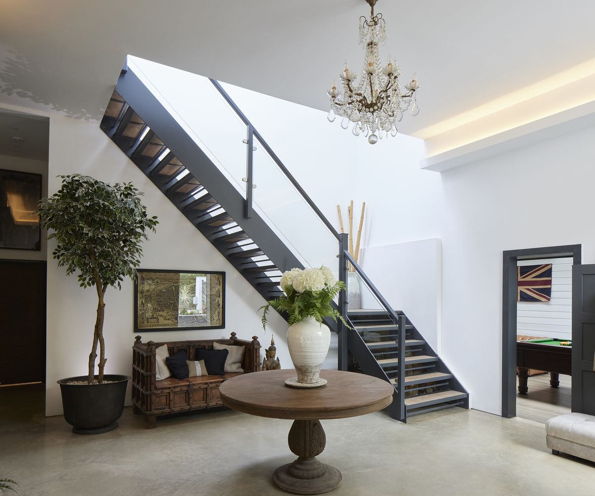 Metal and glass staircase leading up to the first floor from a spacious hallway