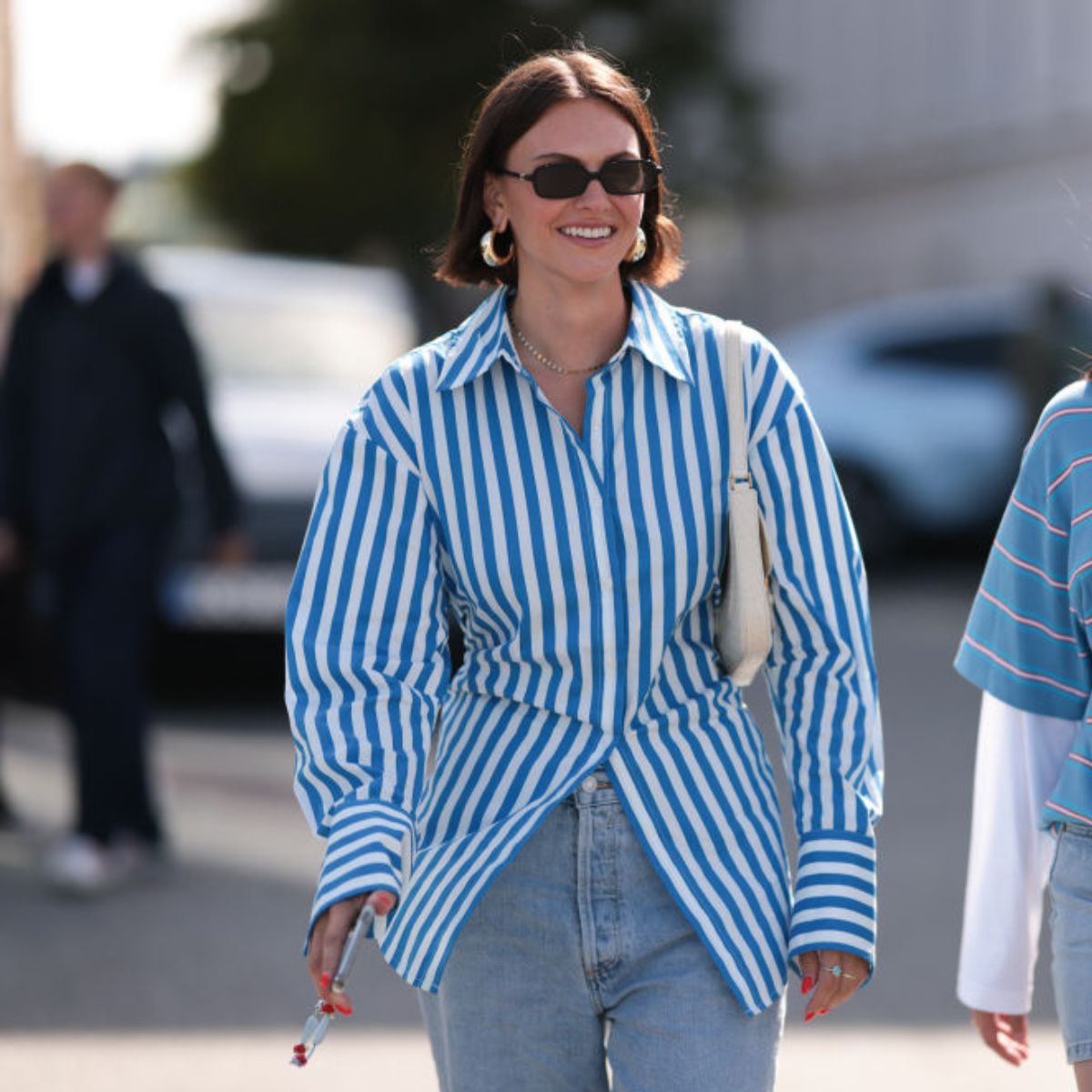 A woman wears a blue and white striped shirt with blue jeans