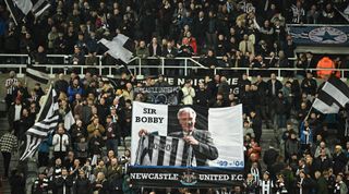 Newcastle United fans display a flag in honour of late manager Sir Bobby Robson ahead of the Premier League match between Newcastle United and Liverpool at St. James' Park on 18 February, 2023 in Newcastle upon Tyne, United Kingdom.