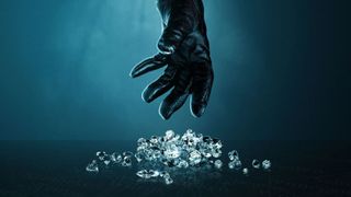 A gloved hand reaches towards a pile of diamonds