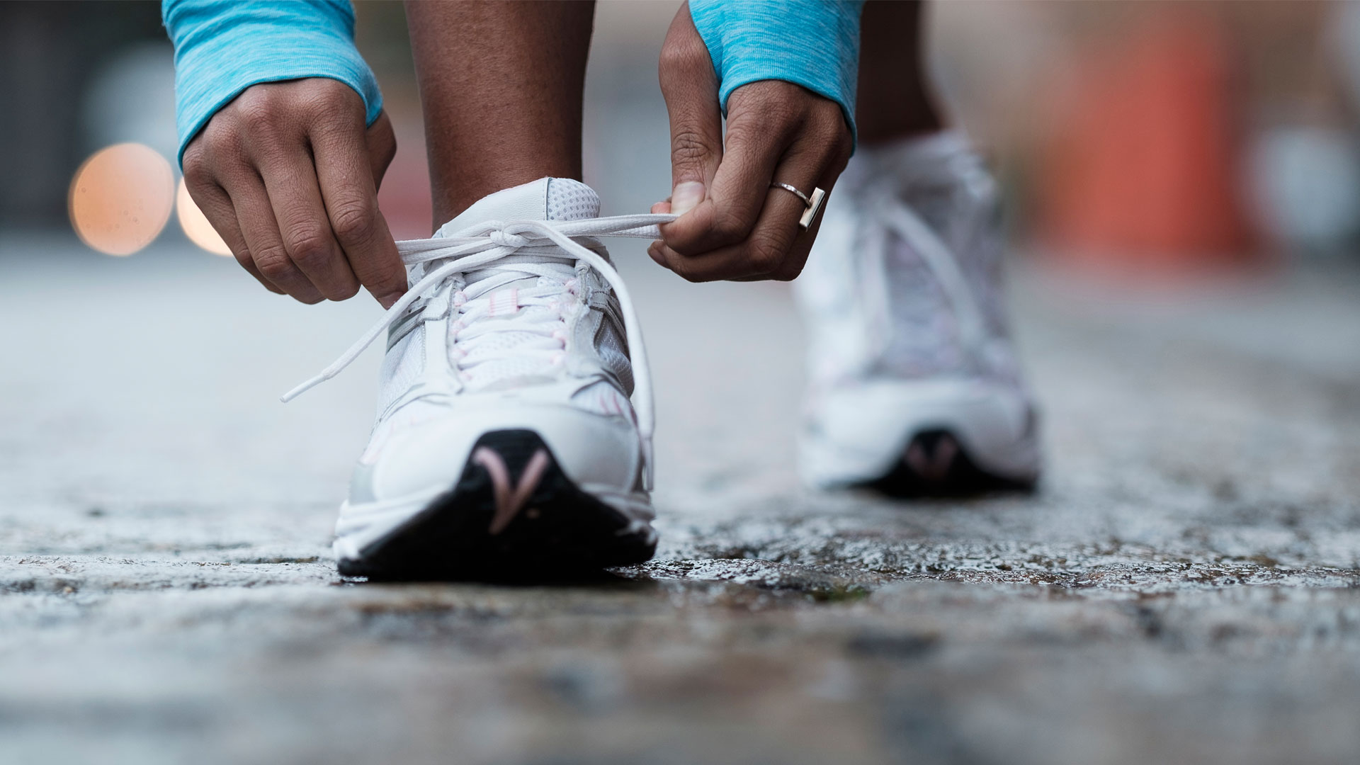 How to run properly: Image shows person tying trainer laces.