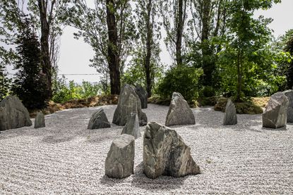 Wabisabiculture garden in Italy's Marche features arrangements of rocks on pebbled floor