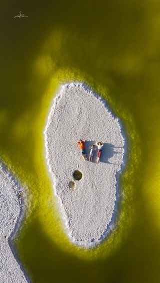 An aerial view of people lying down on an island