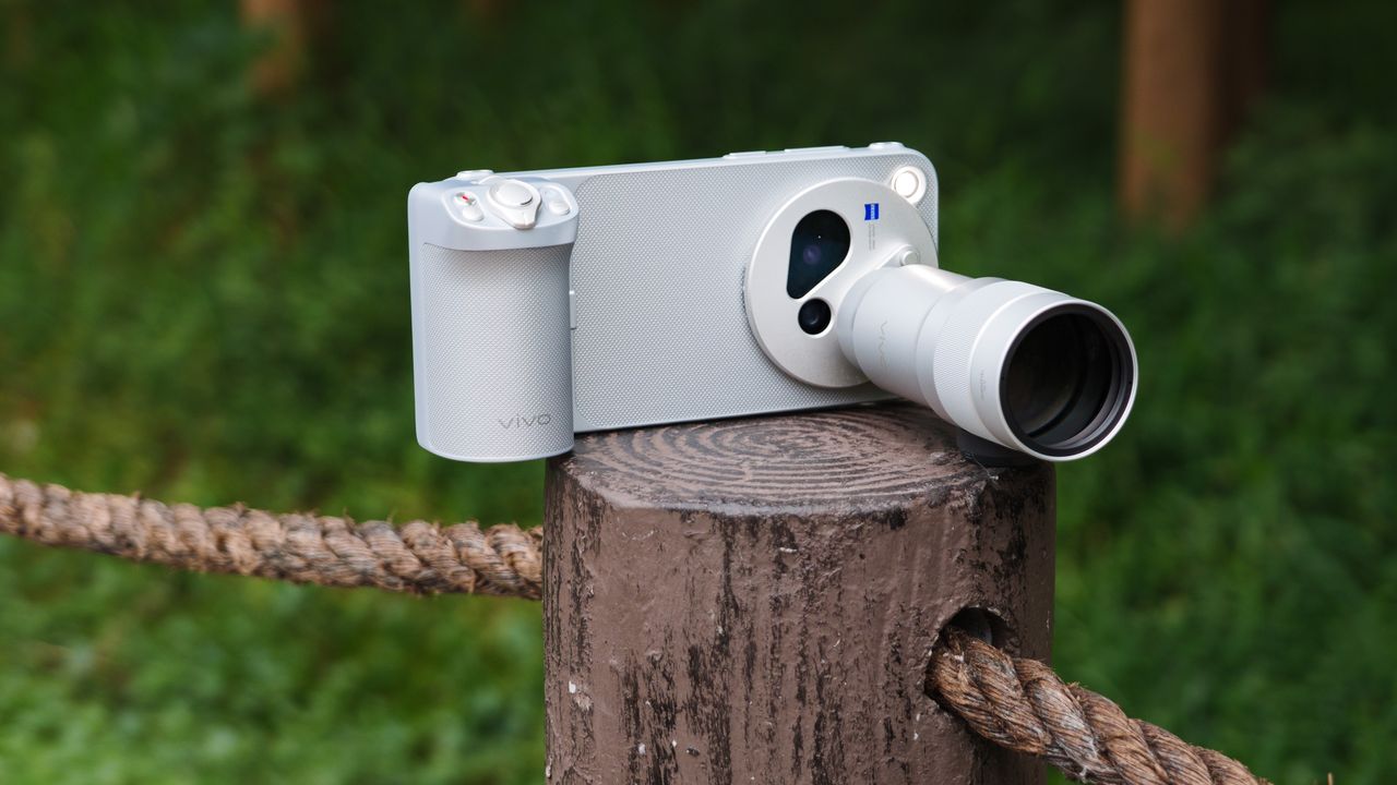 The Vivo X500 Pro Max phone with teleconverter lens attached, on a wooden post besides walkway in a birdlife reserve in Shanghai, China