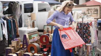 Woman shopping for bargains at a flea market, holding a Victorian slip