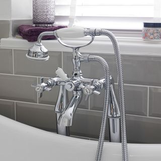 grey brick wall silver taps with hand shower