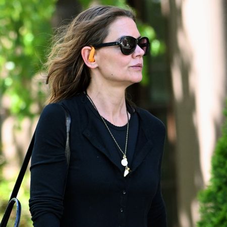 Katie Holmes wearing a black cardigan and a cord necklace