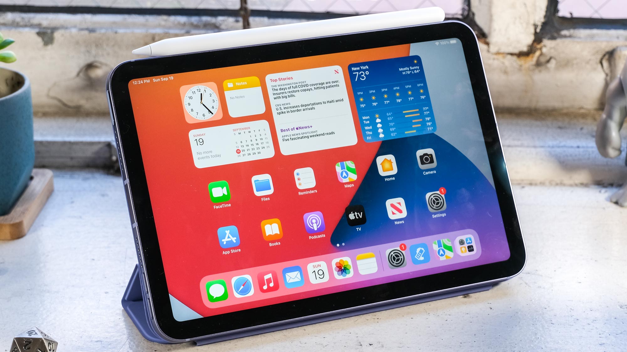 El iPad mini 2021 con Apple Pencil (2.ª generación) y funda Apple Smart Folio morada sobre un escritorio