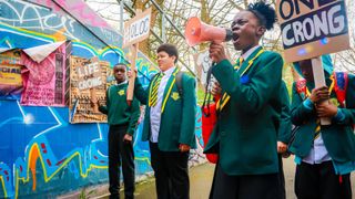 RAPID (SEYI), MCKAY (NOAH), VENETIA (NIELLE), LICCLE BIT (SAMSON) protesting with megaphones in Crongton.