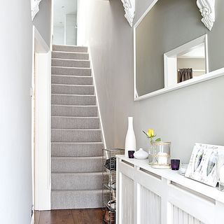 hallway with white wall and storage rack