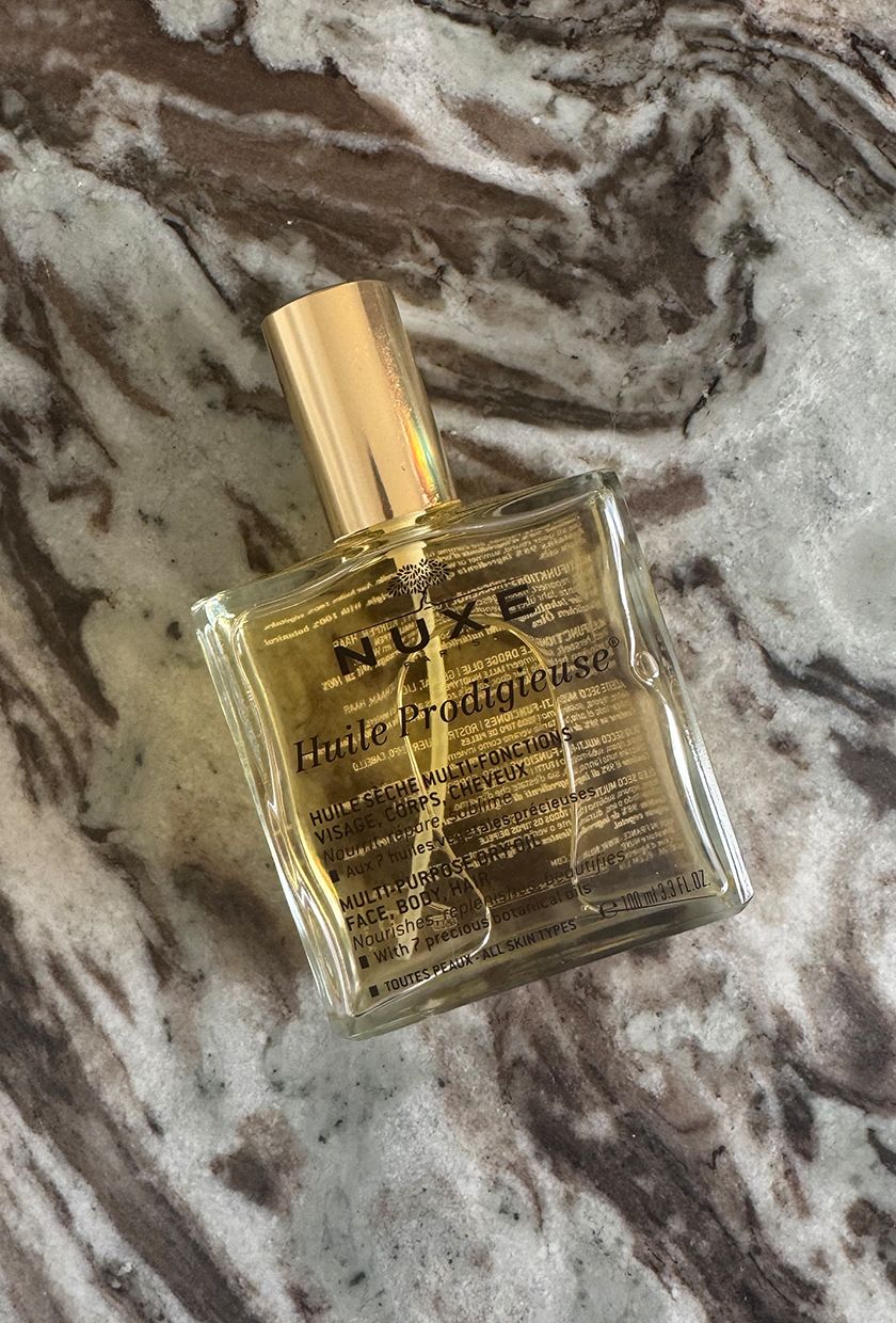 A photo of Nuxe body oil on a marble table