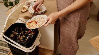 Woman placing food waste in compost bin