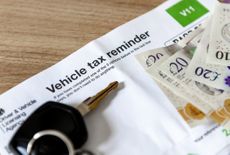 Keys and cash resting on a letter reminding the user to pay their vehicle tax