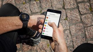 fitness tracker vs running watch: man browsing the Suunto app