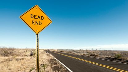 A dead end sign on a desolate road.