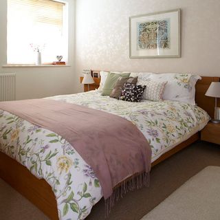 bedroom with floral bedlinen and wallpaper