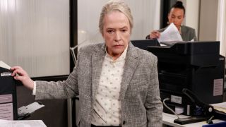 Kathy Bates stands in the print center looking determined in Matlock S1 E8 - "No, Monsters, No."