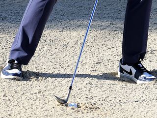 A golf ball plugged in the bunker