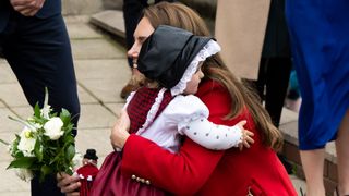 Catherine, Princess of Wales hugs Charlotte after receiving flowers at St Thomas Church