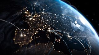 A portion of the globe with countries lit up by their lights at night, and with dotted lights criss-crossing the image connecting the countries