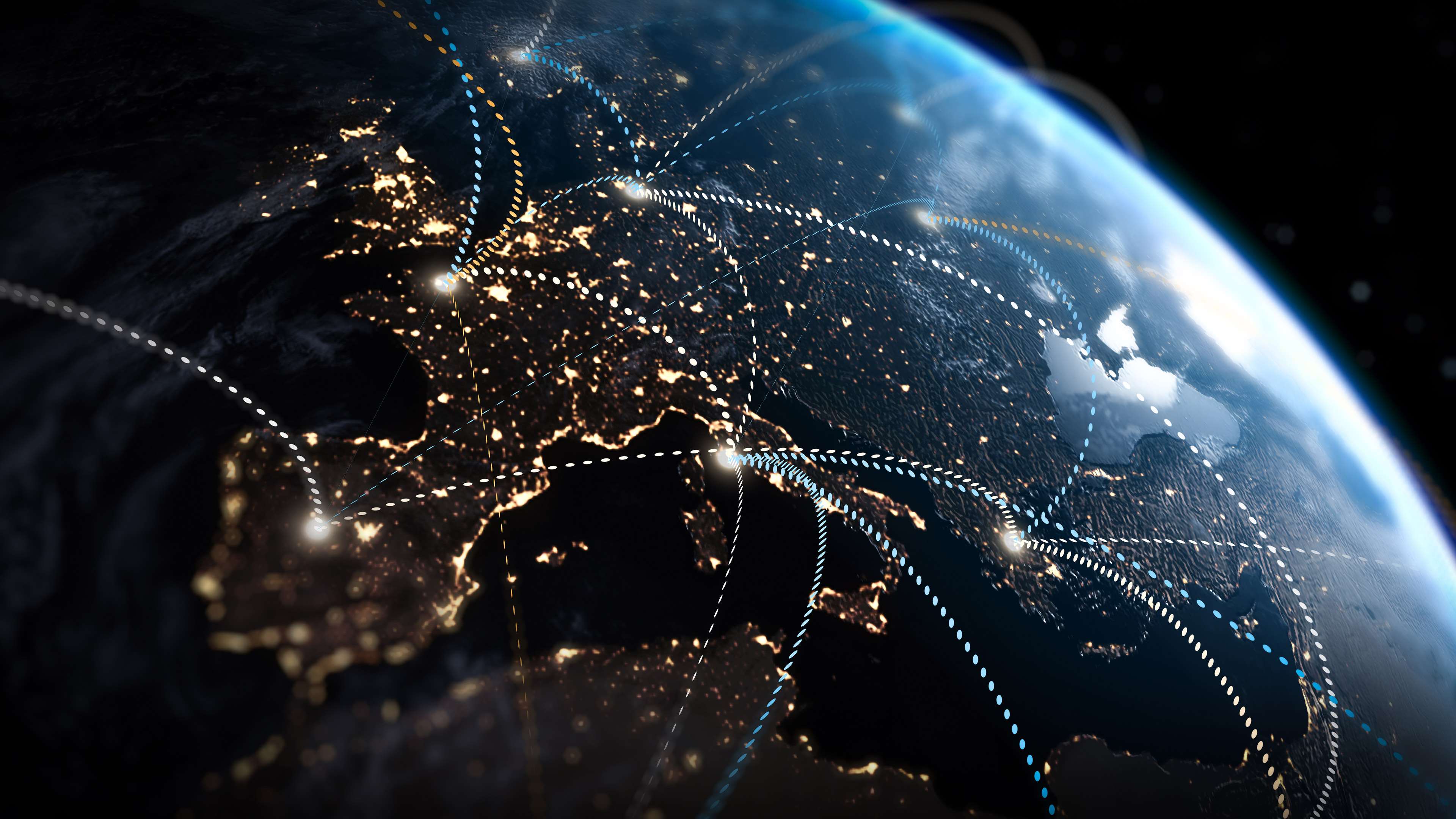 A portion of the globe with countries lit up by their lights at night, and with dotted lights criss-crossing the image connecting the countries