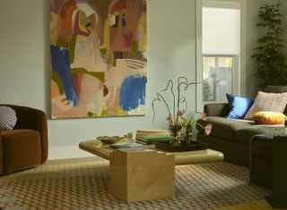 A living room with artwork on the walls, an abstract coffee table and a patterned rug