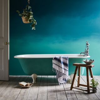 bathroom trends, green/blue bathroom with ombre wall, green bath, wooden floor bards, stool, plant