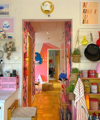 A shot looking down the hallway of a colorful kitchen and living area