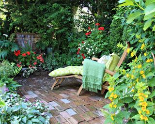 A secluded garden area with overgrown plants and sun lounger