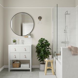 room with round mirror white cabinet and wooden stool