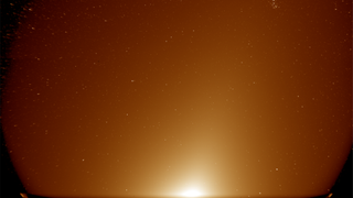A hazy orange glow with stars in the background.